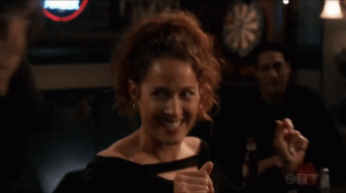 a woman giving a thumbs up in front of a dart board on ctv