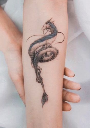 A Woman Has A Tattoo Of A Dragon On Her Forearm GIF