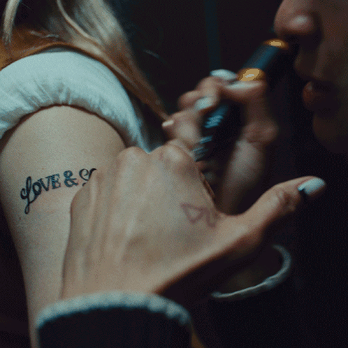 A Woman Has A Tattoo On Her Arm That Says Love & E GIF
