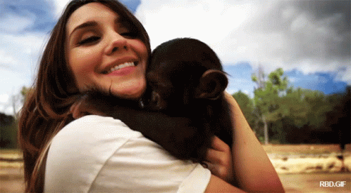 A Woman Holding A Baby Monkey With A Rbd.gif Watermark GIF
