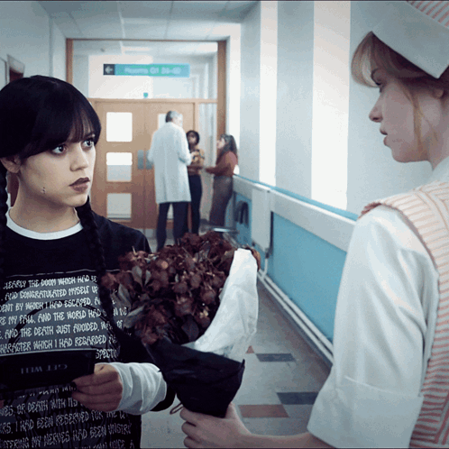 a woman holding a bouquet of flowers in a hallway with a sign that says room of 30-40
