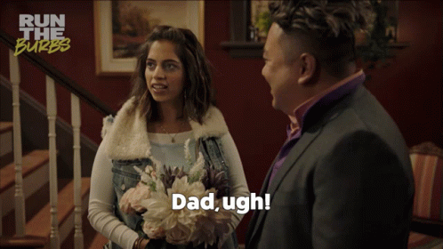A Woman Holding A Bouquet Of Flowers Is Talking To A Man In A Suit Who Says Dad Ugh GIF