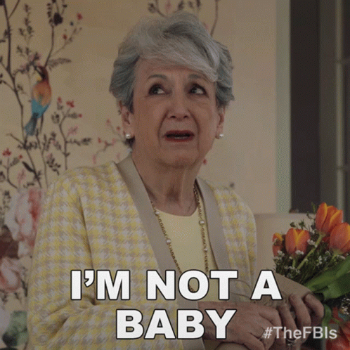 A Woman Holding A Bouquet Of Flowers Says " I 'M Not A Baby " GIF