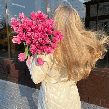 A Woman Holding A Bouquet Of Pink Flowers GIF