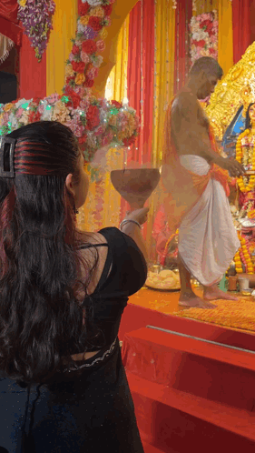 A Woman Holding A Bowl In Front Of A Man GIF