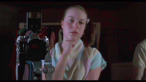 a woman holding a camera with the words " this is looking really good " above her