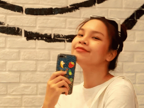 A Woman Holding A Cell Phone With A Strawberry And Kiwi On It GIF