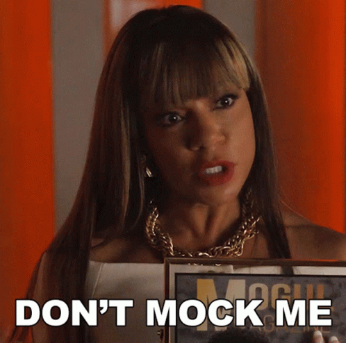 A Woman Holding A Framed Picture With The Words " Do N't Mock Me " On The Bottom GIF