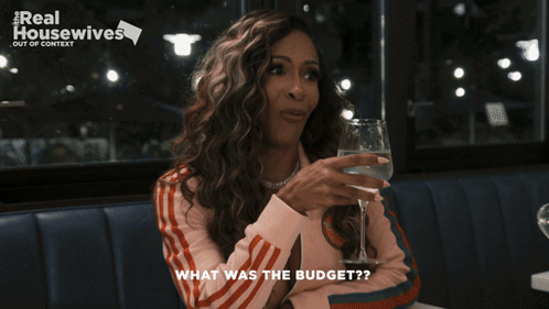 A Woman Holding A Glass Of Water With The Words What Was The Budget Below Her GIF