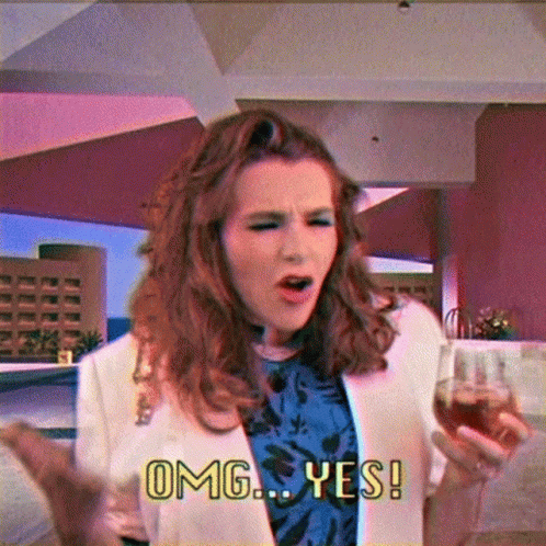 A Woman Holding A Glass Of Wine And Saying Omg Yes GIF
