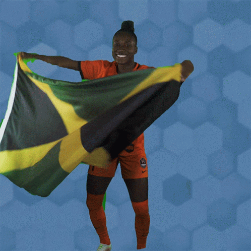 A Woman Holding A Jamaican Flag In Her Hands GIF