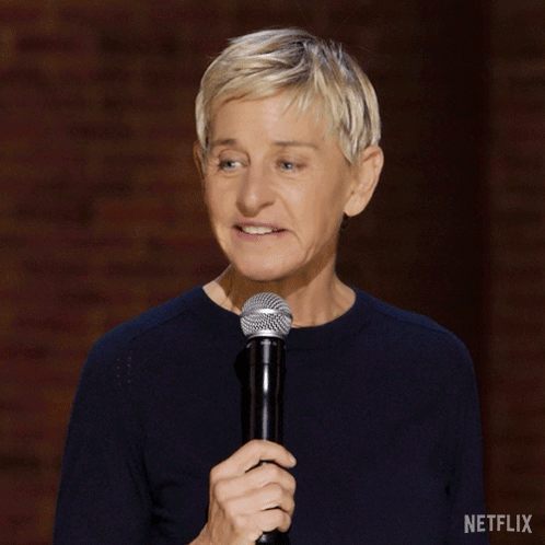 A Woman Holding A Microphone With A Netflix Logo On The Bottom Right GIF