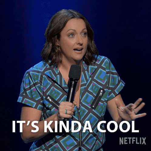 A Woman Holding A Microphone With The Words " It 'S Kinda Cool " Below Her GIF