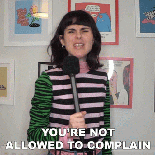 A Woman Holding A Microphone With The Words You 'Re Not Allowed To Complain Below Her GIF