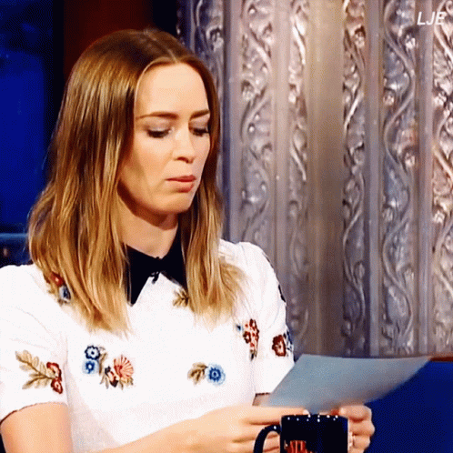 A Woman Holding A Mug And A Piece Of Paper With The Letters Ljb On The Bottom GIF
