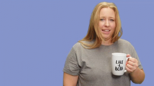 A Woman Holding A Mug That Says Like A Boss On It GIF