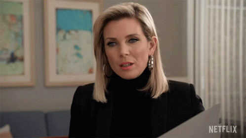 A Woman Holding A Piece Of Paper With Netflix Written On The Bottom Right GIF