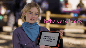 A Woman Holding A Sign That Says " Haha Very Funny " GIF