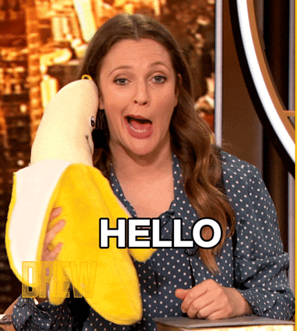 a woman holding a stuffed banana with the word hello written on it