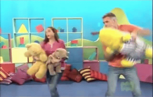 A Woman Holding A Teddy Bear And A Man Holding A Yellow Stuffed Animal GIF