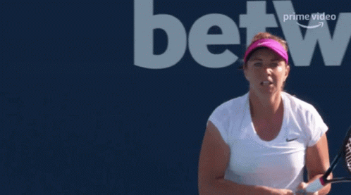 A Woman Holding A Tennis Racquet In Front Of A Betting Logo GIF