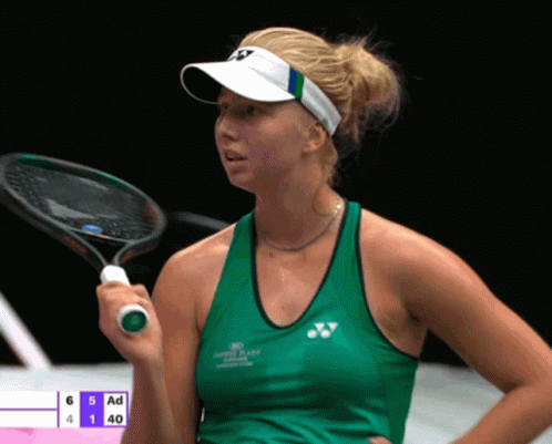 A Woman Holding A Tennis Racquet In Front Of A Scoreboard That Says Ad GIF