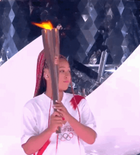 A Woman Holding A Torch That Says Tokyo 20 On It GIF