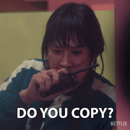 A Woman Holding A Walkie Talkie With The Words Do You Copy Written Below Her GIF