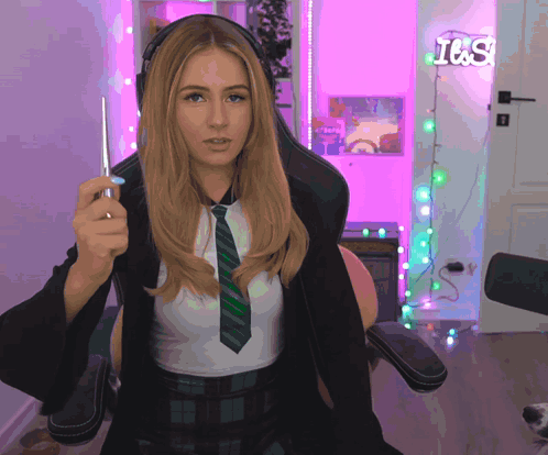 A Woman Holding A Wand In Front Of A Neon Sign That Says I & S GIF