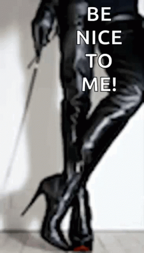 A Woman Holding A Whip With The Words Be Nice To Me Written On The Bottom GIF