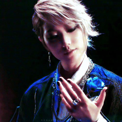 A Woman Holds A Blue Rose In Her Hand With A Ring On Her Left Hand GIF