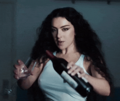A Woman Holds A Bottle Of Wine And A Glass GIF
