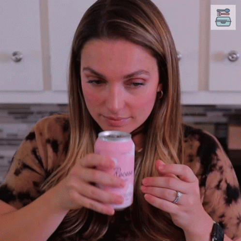 A Woman Holds A Can Of Paradise In Her Hands GIF