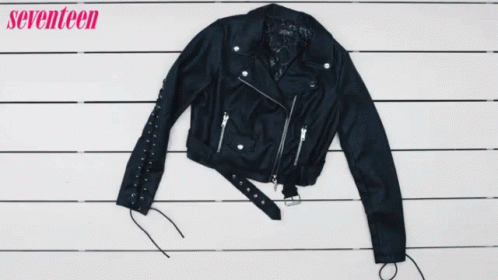 A Woman Holds A Pair Of Black Boots Next To A Plaid Shirt And A Leather Jacket GIF