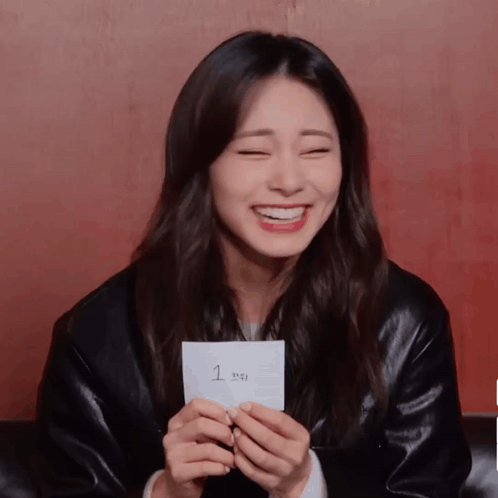 A Woman Holds A Piece Of Paper With The Number 1 On It GIF