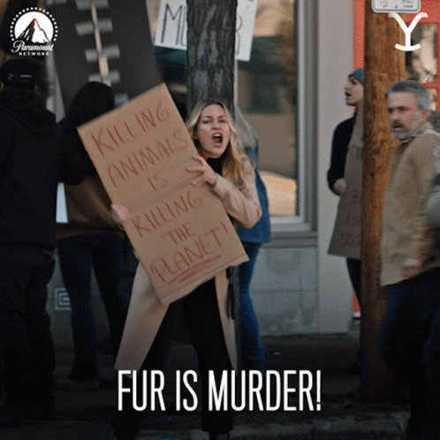 A Woman Holds A Sign That Says Killing Animals Is Killing The Planet GIF