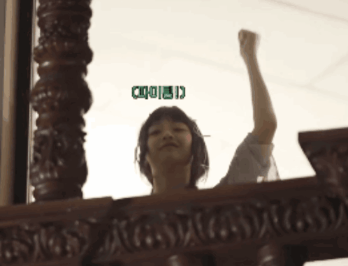 A Woman Holds Her Fist Up In The Air With A Green Sticker That Says ' I ' On It GIF