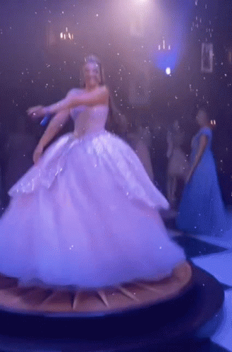 A Woman In A Ball Gown Is Dancing On A Clock GIF