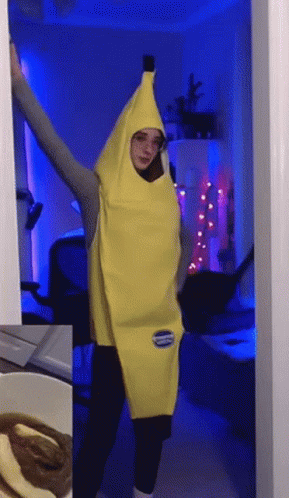 A Woman In A Banana Costume Is Standing In A Doorway With Her Arms Outstretched GIF