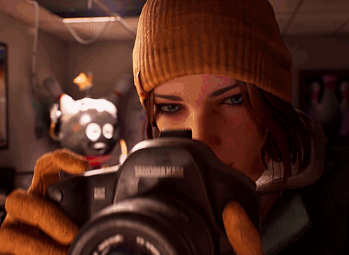 a woman in a beanie is taking a picture with a camera that says ' vanderbilt ' on it