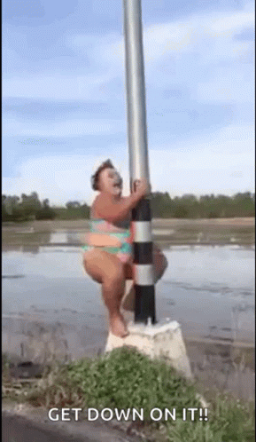 A Woman In A Bikini Is Hanging On A Pole . GIF