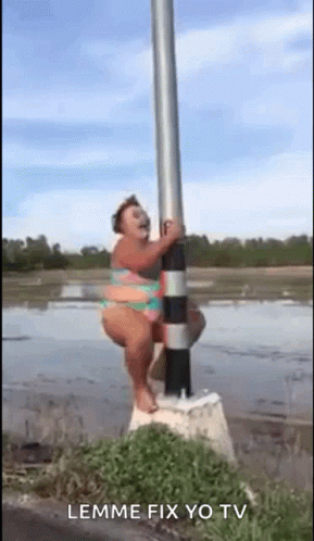 A Woman In A Bikini Is Sitting On A Pole In The Water . GIF