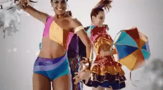 a woman in a bikini stands next to another woman in a colorful dress