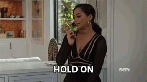 A Woman In A Black And Gold Dress Is Talking On A Cell Phone And The Word Hold On Is Visible GIF