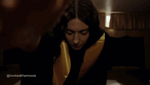 A Woman In A Black And Gold Robe Is Looking At The Camera With The Words Invited The Movie Below Her GIF