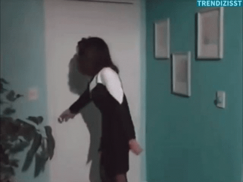 Woman In Black And White Dress Holding Door Open GIF