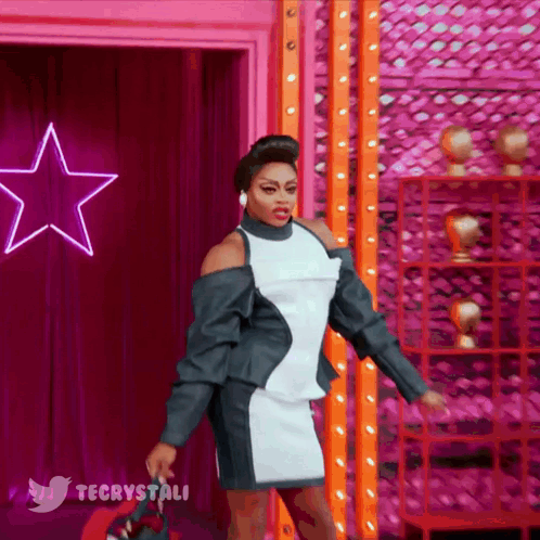 Woman In Black And White Dress In Front Of Pink Star And Twitter Logo GIF
