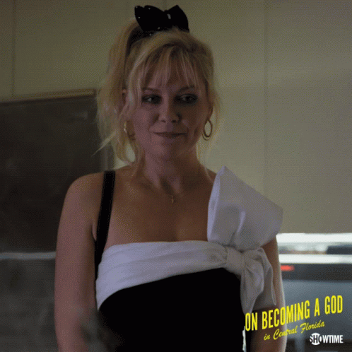 A Woman In A Black And White Dress With The Words On Becoming A God In Central Florida GIF