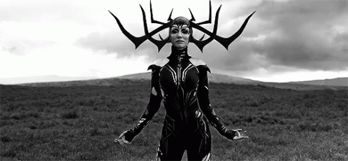 A Woman In A Black And White Photo Is Standing In A Field With Her Arms Outstretched . GIF