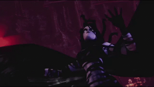 A Woman In A Black And White Striped Dress Is Standing In The Dark GIF